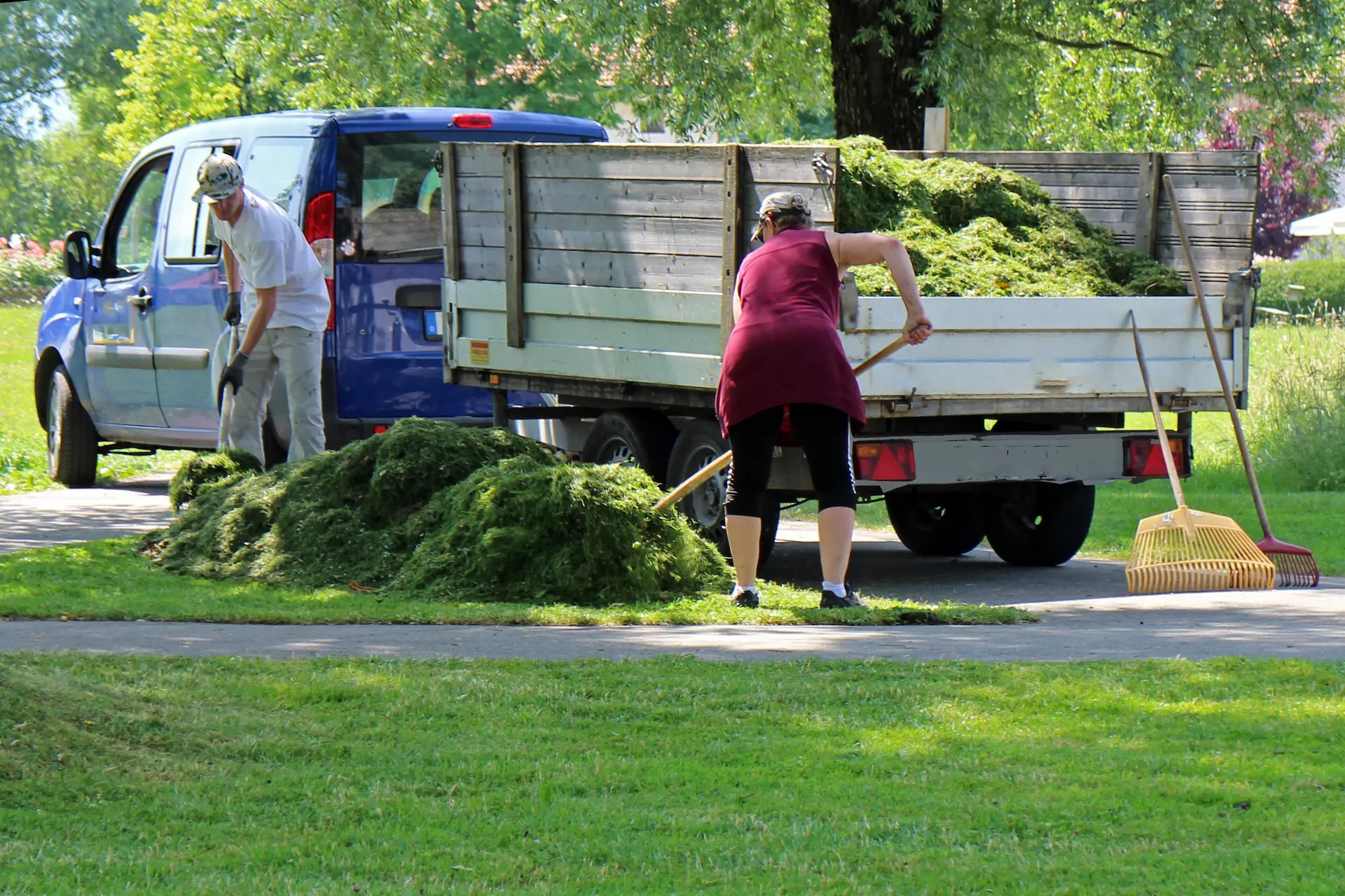 Landscaping crew loading cleanup debris into a work truck